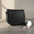 Sac bandoulière en cuir véritable noir, avec anse amovible et attaches à boucles dorées brillantes, format 26 × 20 × 10 cm.
