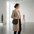 Sac bandoulière en cuir véritable noir, avec anse amovible et attaches à boucles dorées brillantes, format 26 × 20 × 10 cm.