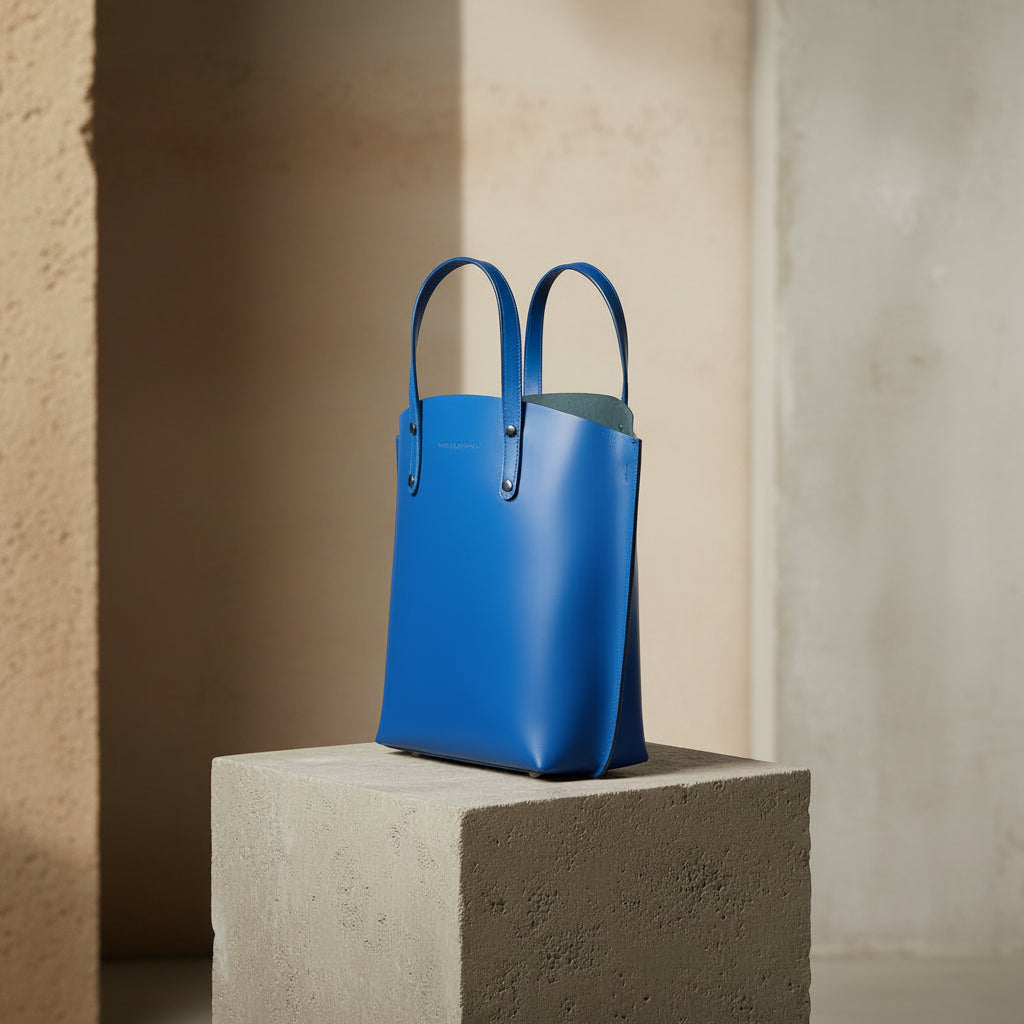 Grand sac à main en cuir véritable bleu royal, avec bandoulière amovible, pochette interne extractible et finitions canon de fusil brillantes, format 48 × 31 × 11 cm. 