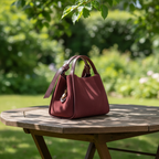 Sac Alice en cuir suédé bordeaux avec insertions en cuir grainé dollar, silhouette trapèze structurée et accessoires dorés brillants, fabriqué en Italie.