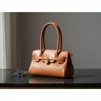 Sac porté épaule Arianna en cuir sauvage souple couleur cognac, fabriqué en Italie, avec métallerie or mat et format 34 × 15 × 16 cm, poignée de 20 cm.